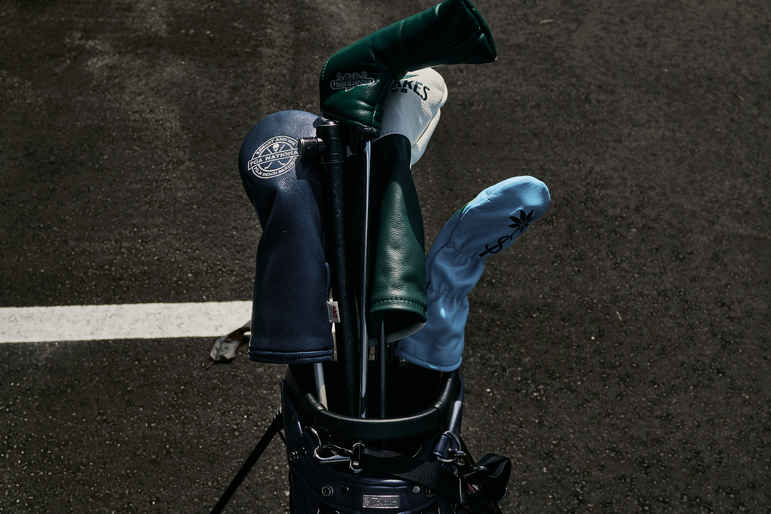 Titleist golf bag with Shell Bay, PGA National Resort, Fisher Island, and Miami Lakes headcovers.